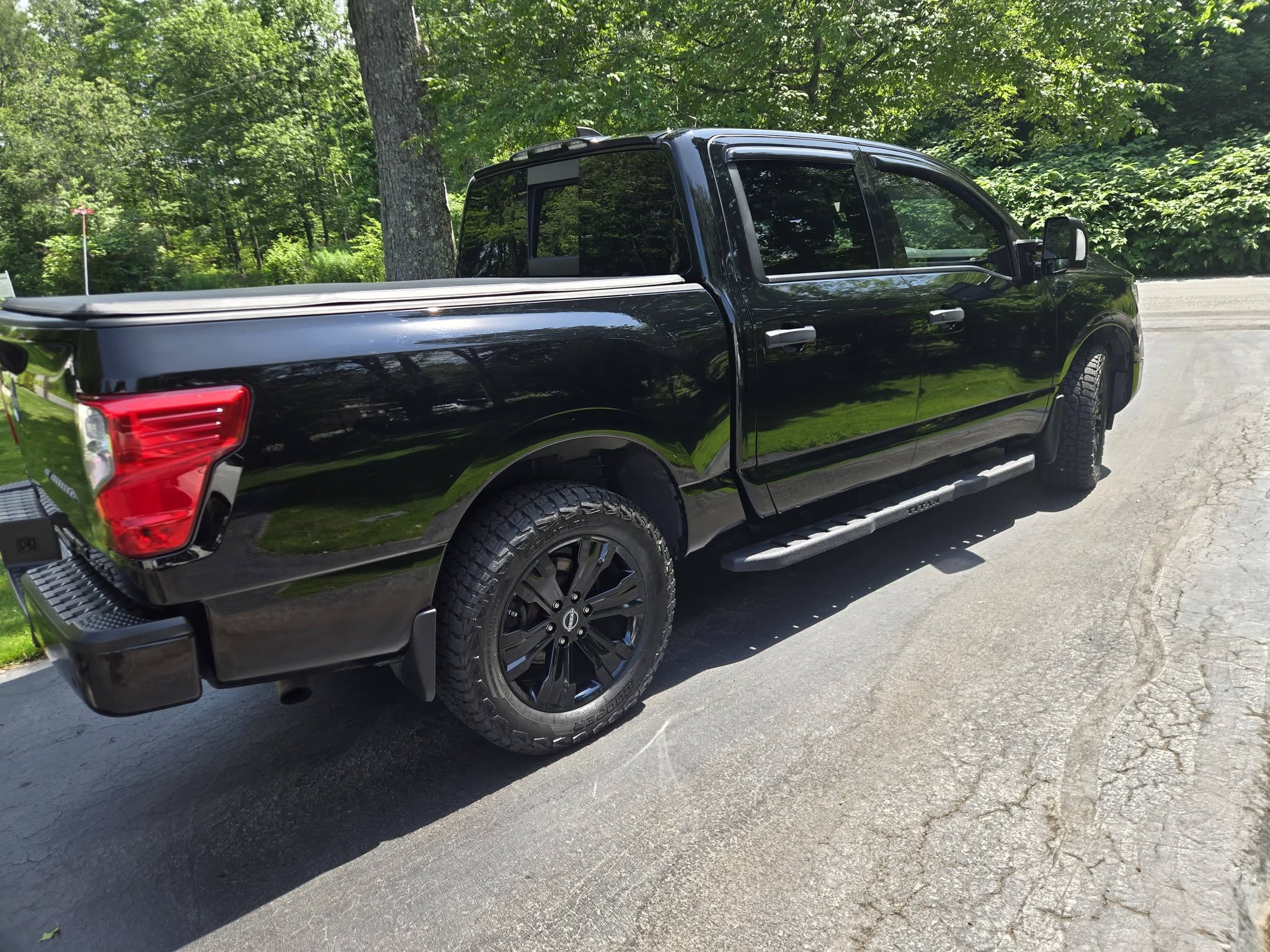 Black Nissan Titan pickup detailed to a glossy black finish